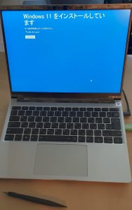 組立が完成したノートパソコンを開いた状態。ブルースクリーンに「Windows 11をインストールしています」とのメッセージが表示されている。キーボードは日本語配列。パソコンの前にはペンの形をした組み立てツール(ドライバー)が置かれている。
